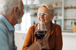 © Goran - Happy mature woman talking to her husband while enjoying in wine at home