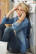 © auremar - worried woman talking on smartphone in utility room