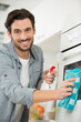 © auremar - portrait of man spraying product to clean oven
