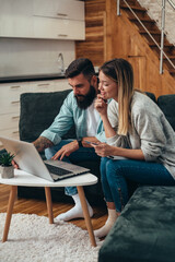 Couple shopping online with laptop