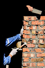 Low Angle View Of Man Working On Wall