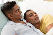 © wavebreak3 - Diverse gay male couple lying on sofa and embracing