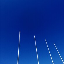 Low Angle View Of Vapor Trails Against Clear Blue Sky