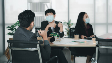 Wall Mural - Group of young business people sit at their desks with smiling colleagues together in the office.  Meeting business people  planning concept, laptop meeting ideas. Concentrate on work. LGBT teamwork.