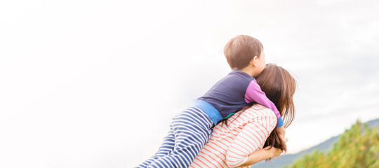 Wall Mural - Portrait of asian mother and toddler boy child playing having fun.Travel Happy son and mom laughing hugging in playground outdoor.family asian korean mom.Mother’s day holiday.People mother child.