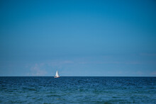 Sailboat Sailing In Sea Against Blue Sky
