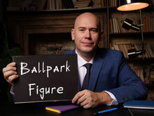 A Handsome Businessman Showing A Blank Piece Of Paper With Sign Ballpark Figure .