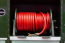  Coiled Or Rolled Red Rubber Fire Hose Seen On An Old Green Goddess