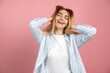 © speed300 - Happy, beautiful girl is smiling happily, touching her hair. Young girl posing on a background of a pink wall.