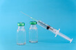 © photobuay - Potential trials stage concept on blue background. Close up Vials with sterile needle syringe. Research and Development, Vaccination.
