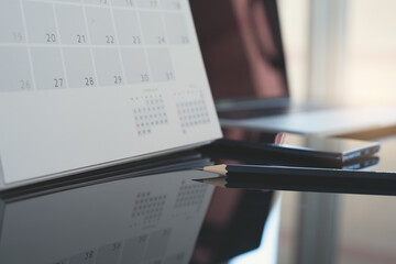 Business workspace,  black pencil, desktop calendar and laptop computer on table in office with nobody