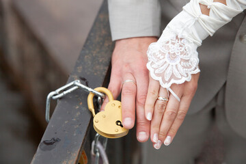 Poster - the bride's hand and the bride's that closed the heart-shaped lock. wedding custom