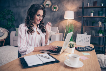 Wall Mural - Photo of charming sweet young lady wear white shirt spectacles talking modern gadget sitting table indoors inside room home