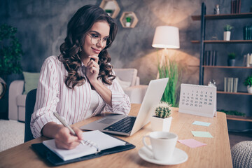 Poster - Photo of beautiful thoughtful young woman dressed striped shirt glasses looking modern device writing pen inside indoors home room