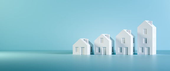 which size of house can you afford? concept shot: four differently sized models of houses on a blue 