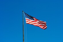 Low Angle View Of American Flag Against Clear Blue Sky