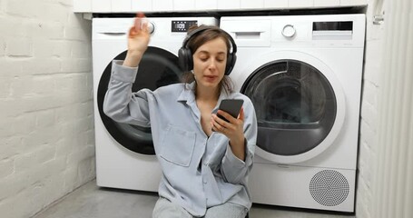 Wall Mural - Woman enjoys while washing clothes at home