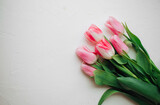 Fototapeta Tulipany - Pink tulips bouquet on white background, copy space, top view