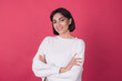 © Анастасия Каргаполов - Beautiful woman in casual white sweater on pink red background with crossed hands smile look to camera isolated copy space