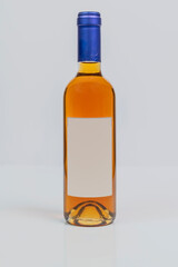 Vin santo wine in super bordeaux style bottle on white surface and background