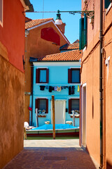 Wall Mural - Small street by canal in Burano island in Venice