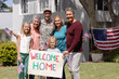 © WavebreakMediaMicro - Happy caucasian soldier father, wife, children and parents outside home with welcome sign and flags