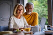 © PhotoAlto - Portrait of smiling mature couple using laptop at home