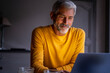 © PhotoAlto - Smiling mature man using laptop at home