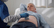 Senior man getting ultrasound examination on abdomen from doctor