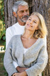 © PhotoAlto - Thoughtful mature couple leaning on tree trunk