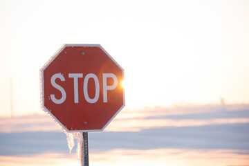 stop sign on a snow and sunny day