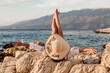 Female with a hat relaxing on a beach in Croatia