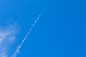 Wall Mural - small white plane with white smoke trail on the blue sky.