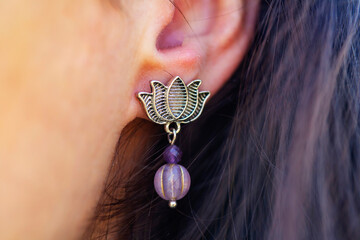 Wall Mural - Detail of female ear wearing stone mineral floral shape bead earring