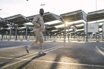 Closeup shot of a Black young male standing outdoors under the sunlight