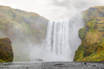 Wall Mural - Misty Skogafoss waterfall in cloudy weather.Iceland