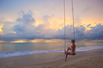 Wall Mural - Young Woman swinging at tropical beach in Thailand