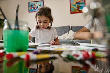 Adorable children performing watercolor painting technique during indoor creativity lesson. Home education concept