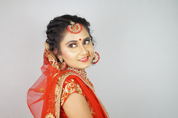 Wall Mural - Gorgeous Indian bride with heavy makeup wearing traditional Indian bridal attire and posing