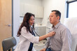 © Lynsey Weatherspoon/Creative Flame - Asian doctor checks patient heartbeat using stethoscope