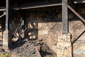 Wall Mural - Crumbling concrete and brick wall, outriggers of steel I-beams, rubble beneath, horizontal aspect