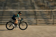 © Friends Stock - Side view of professional female cyclist in cycling garment and protective gear riding bicycle in city, rushing and passing buildings while training outdoors on a daytime