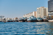 © dimo - Dubai creek and water traffic there: cargo ships, touristic boats and docked ships