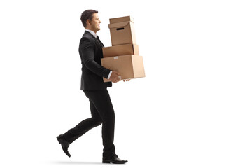 Full length profile shot of a businessman walking and carrying boxes
