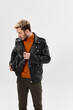 © SHOTPRIME STUDIO - stylish blond man in an orange sweater and a jacket on a light background brown trousers