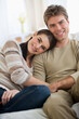 © Tetra Images/Tetra Images - Portrait of happy couple sitting on sofa