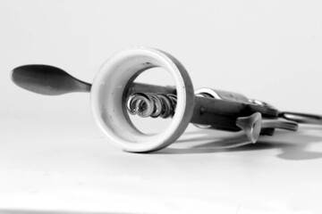 Wall Mural - Black-and-white photo of a metallic corkscrew on a white background