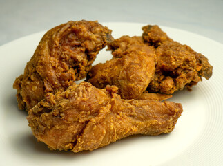 Wall Mural - Fried chicken pieces on a bank plate, chicken breaded with spices.