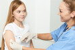© SHOTPRIME STUDIO - female doctor giving an injection to a girl in the hand of a hospital health covid