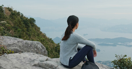 Sticker - Woman sit on the rock at the top of the mountain